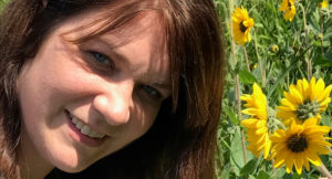 Petra Stockhaus, Clinical Supervisor, headshot with flowers in the background